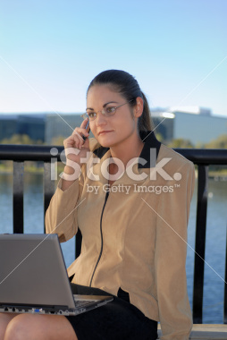 stock-photo-3130754-business-woman-talking-on-cell-phone-with-a-computer