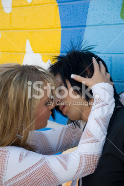 teenage couple kissing in front of a grunge background