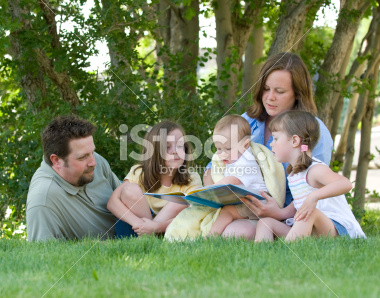 Family reading a book together in the park