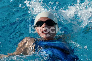 Swimmer swimming the backstroke at a swim meet